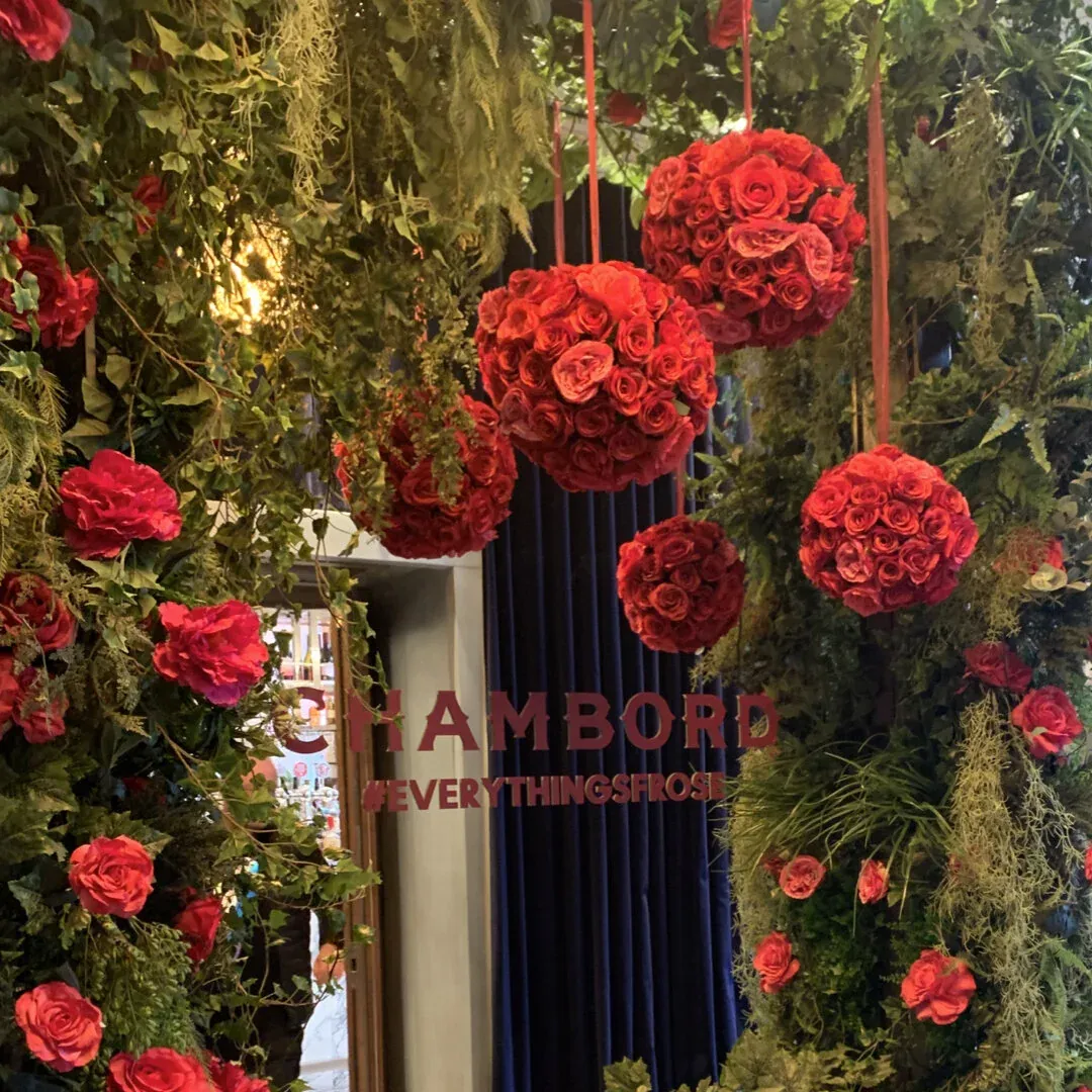 Red rose spheres hanging in greenery for Chambord