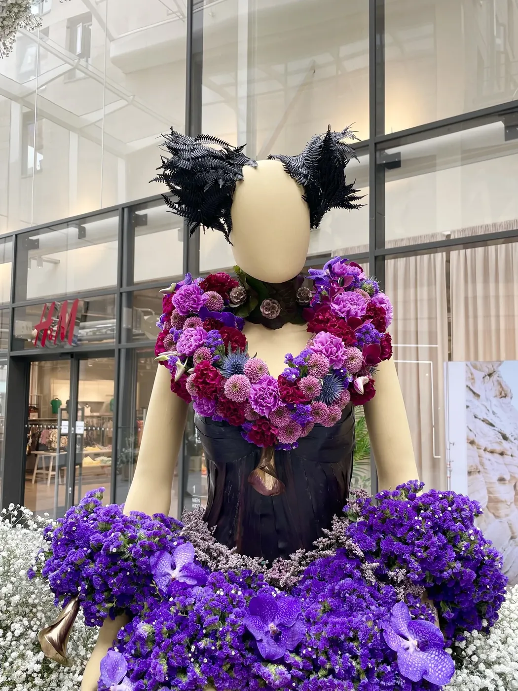 A mannequin in a gown of purple orchids and hydrangea