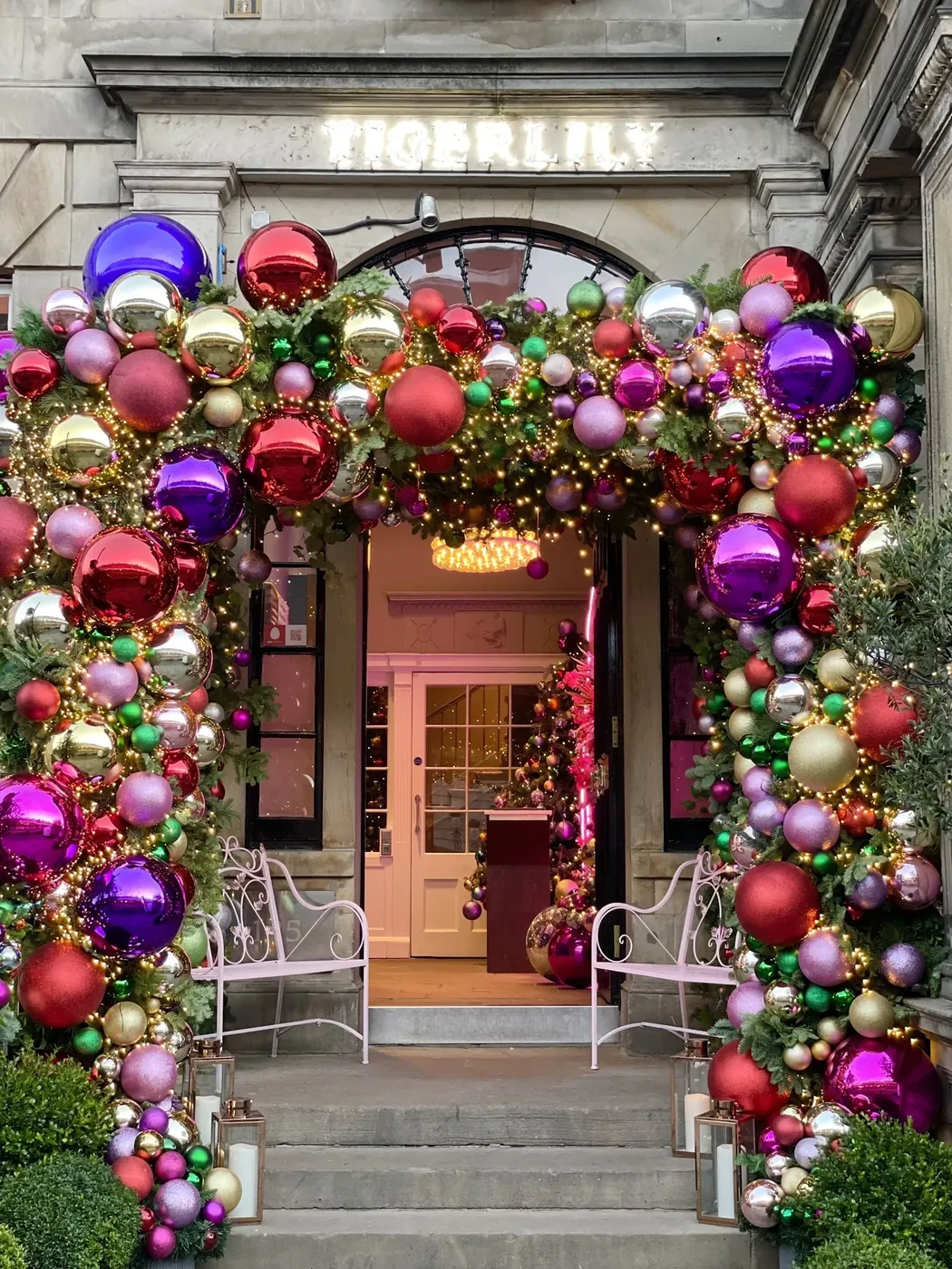 Steps and a doorway framed in red, purple and silver baubles