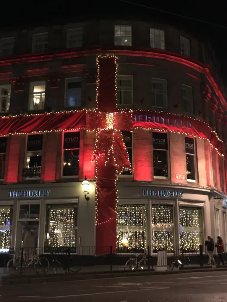 A building wrapped in red ribbon lights at night