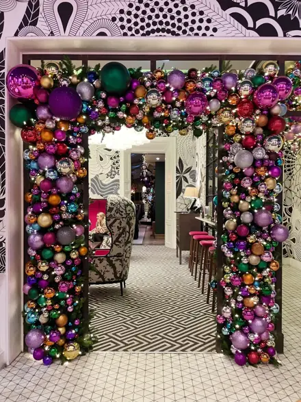 A doorway framed in jewel-coloured baubles