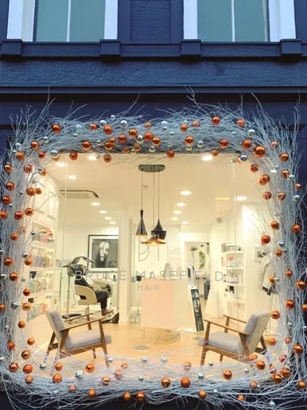 A window framed in white branches and copper baubles at Bruce Masefield