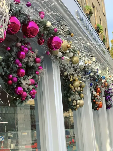Magenta and gold bauble swags along a shopfront
