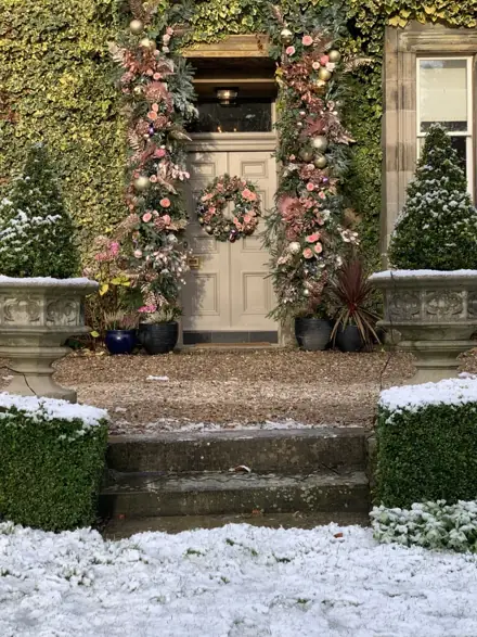 A snowy doorway dressed in pink and green
